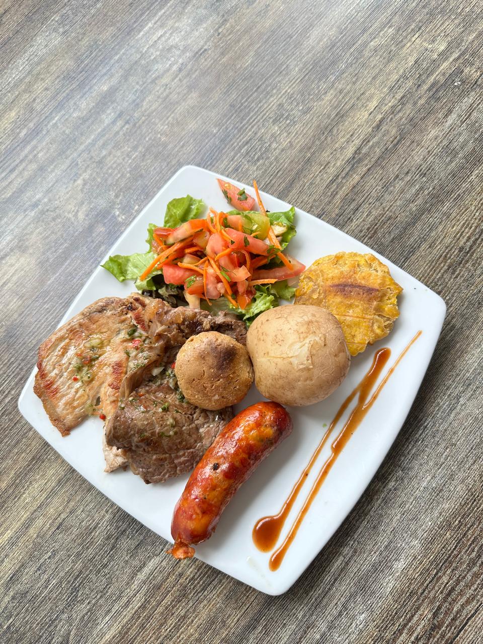 Plato ejecutivo con carne, chorizo, papa criolla y ensalada fresca